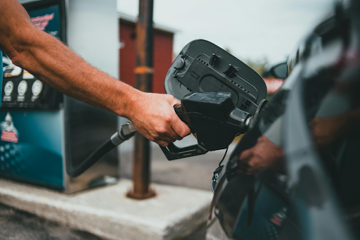 Fueling up at a gas station, illustrating the high fuel costs associated with RV ownership, especially during long road trips.