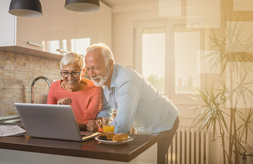 Happy couple reviewing financial options on their computer, highlighting the personal service and community focus of a Florida credit union.