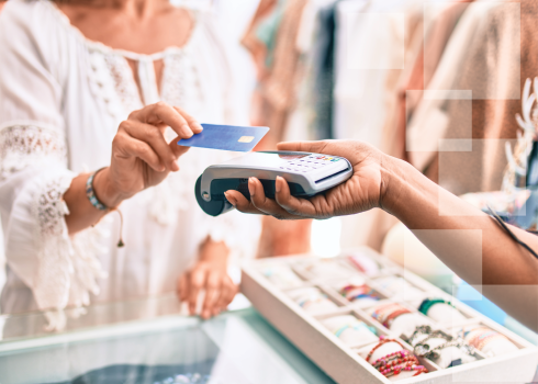 Customer making a purchase with a credit card at a retail counter, highlighting the responsible use of credit cards for financial growth